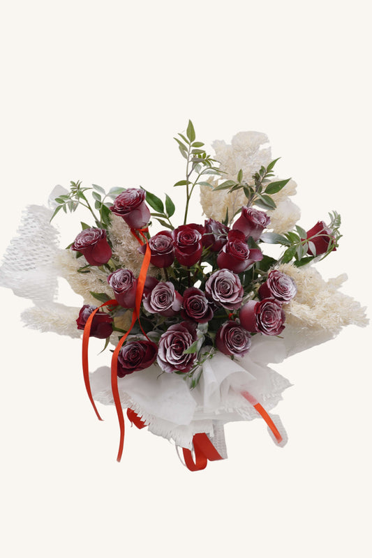 Bouquet of red roses with greenery on a white background